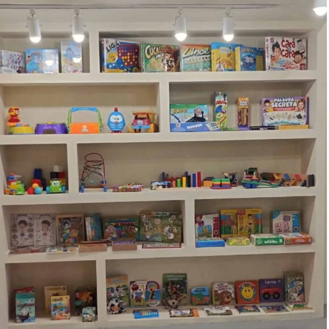 Estante com jogos e materiais terapêuticos organizados